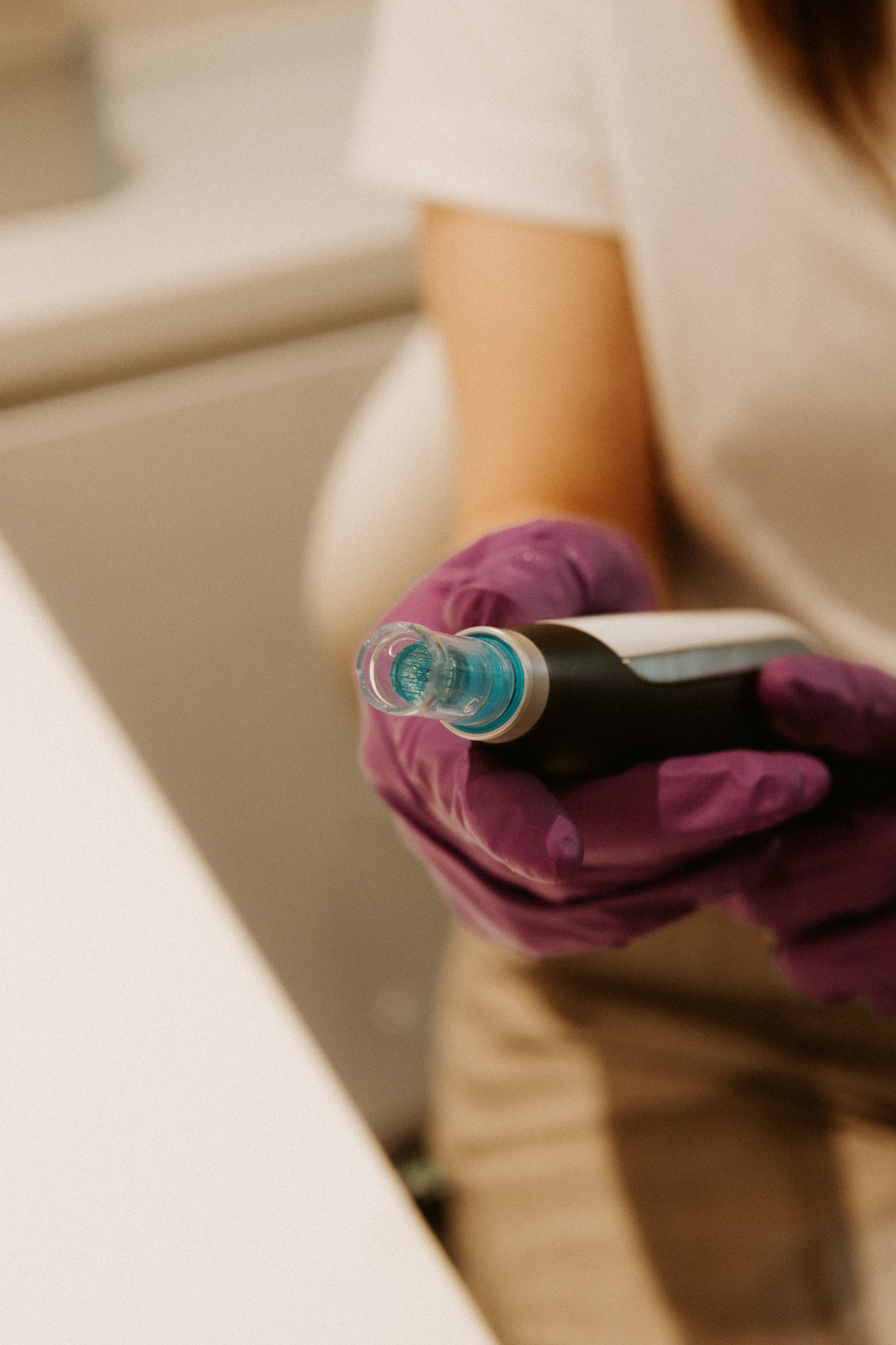 een vrouw houdt het Microneedling apparaat vast 