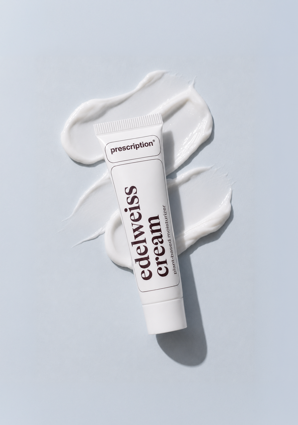 een Edelweiss Cream mini tube met daaronder een kleine veeg edelweiss cream, om de texture te tonen